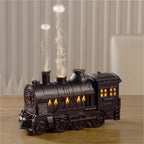 Black train aroma diffuser with steam-like mist on a table