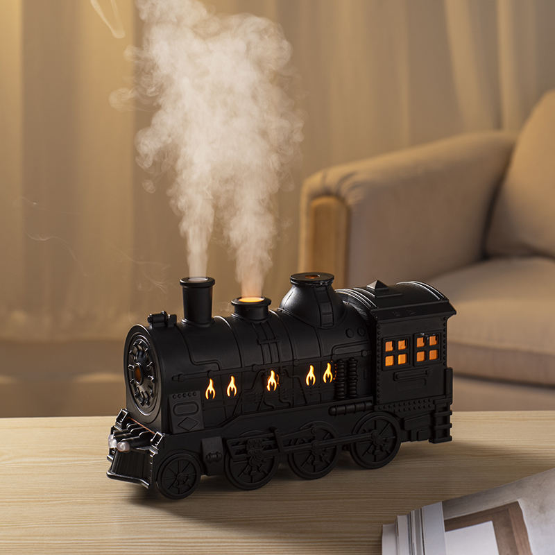 Black train aroma diffuser releasing mist on a table